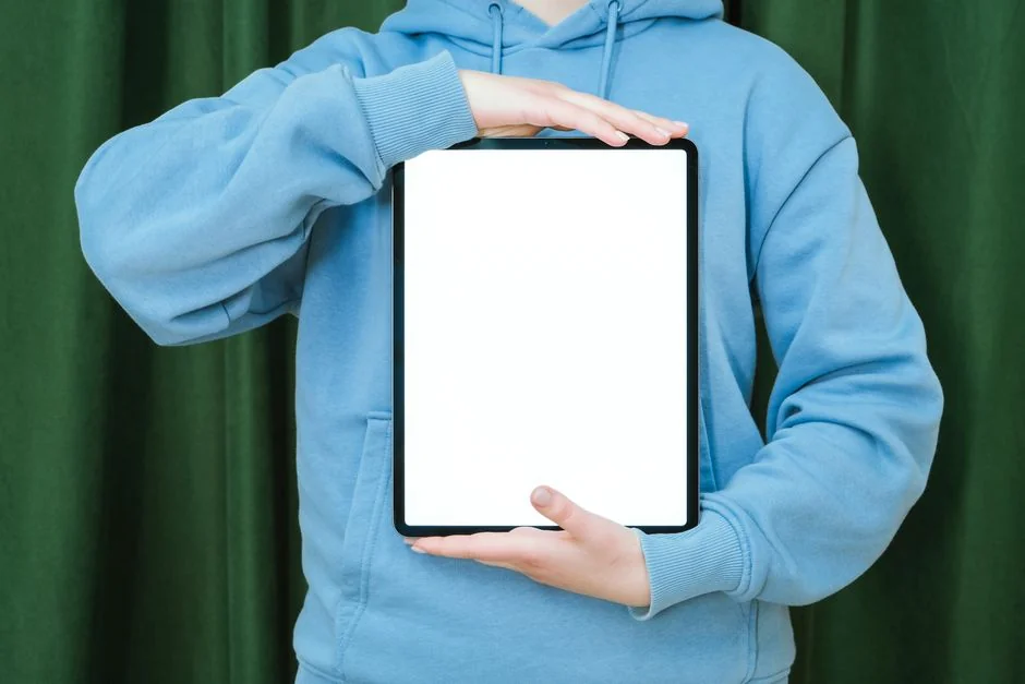 A person writing in a notebook, focusing on pencil sketching and typography design.